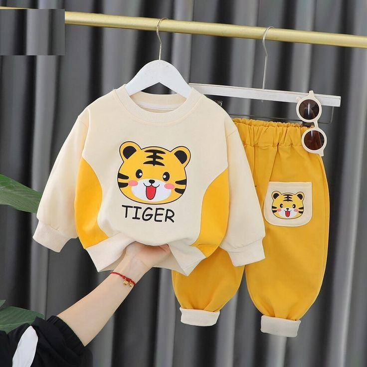 Children's outfit with tiger design on a hanger against a gray curtain background