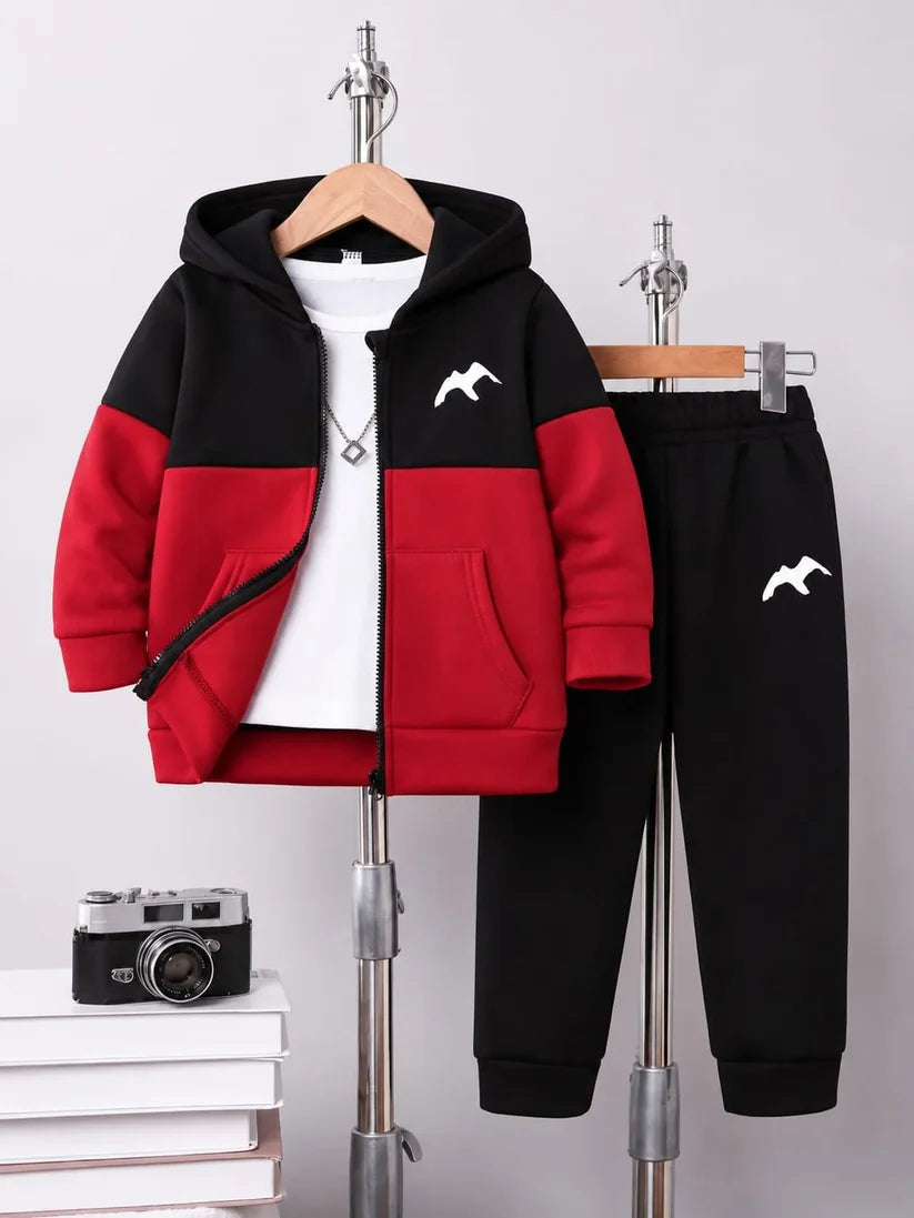 A children's two-piece tracksuit displayed on hangers against a light gray background. The set includes a zip-up hoodie with a black and red color-blocked design, a white chest graphic, and a matching black jogger sweatpants with a small white chest graphic.