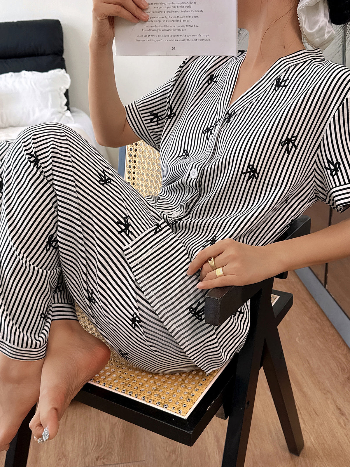 Person wearing a black and white striped outfit sitting on a chair.