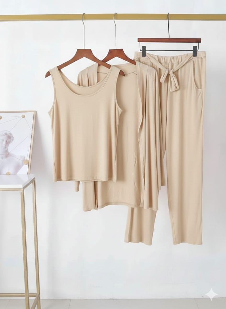 Beige tank top and pants on hangers against a white wall.