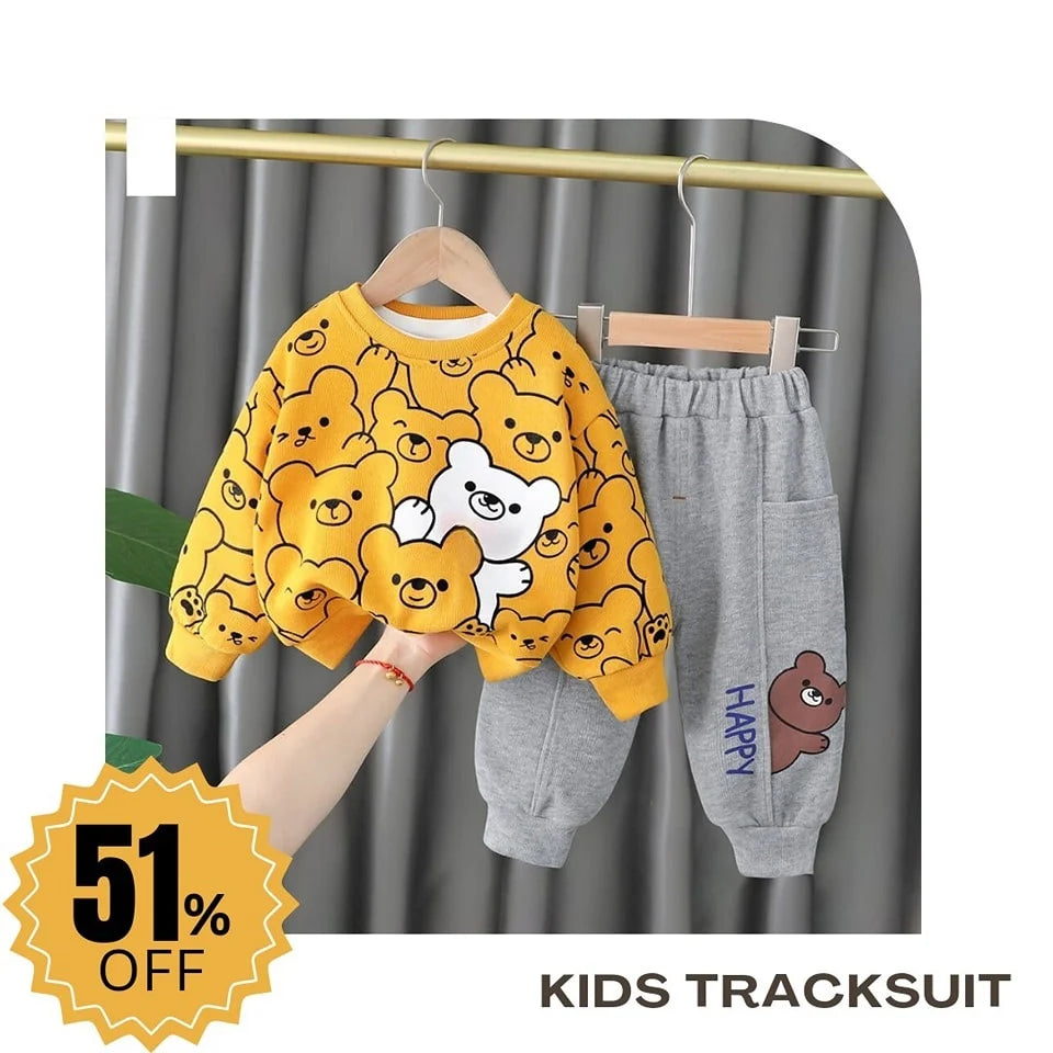 Children's tracksuit with yellow sweater and gray pants on a hanger against a gray curtain background.